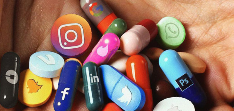 Hand voller bunter Pillen in Form bekannter App‑ und Social‑Media‑Logos